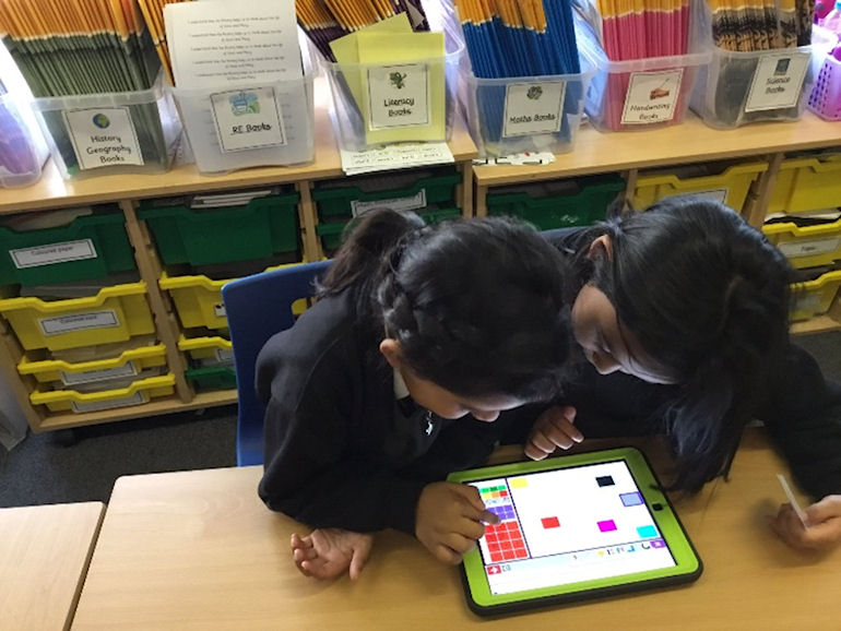 Two children using a touch-screen pad in Computing
