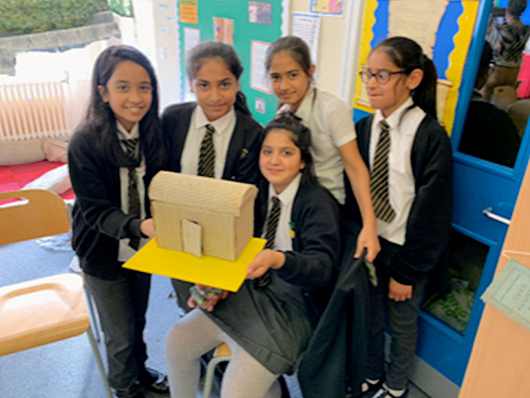 A group of children displaying their hand-built model building